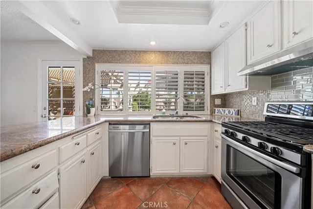 a kitchen with granite countertop white cabinets and appliances