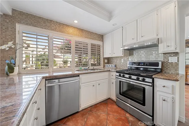 a kitchen with granite countertop a stove and a sink
