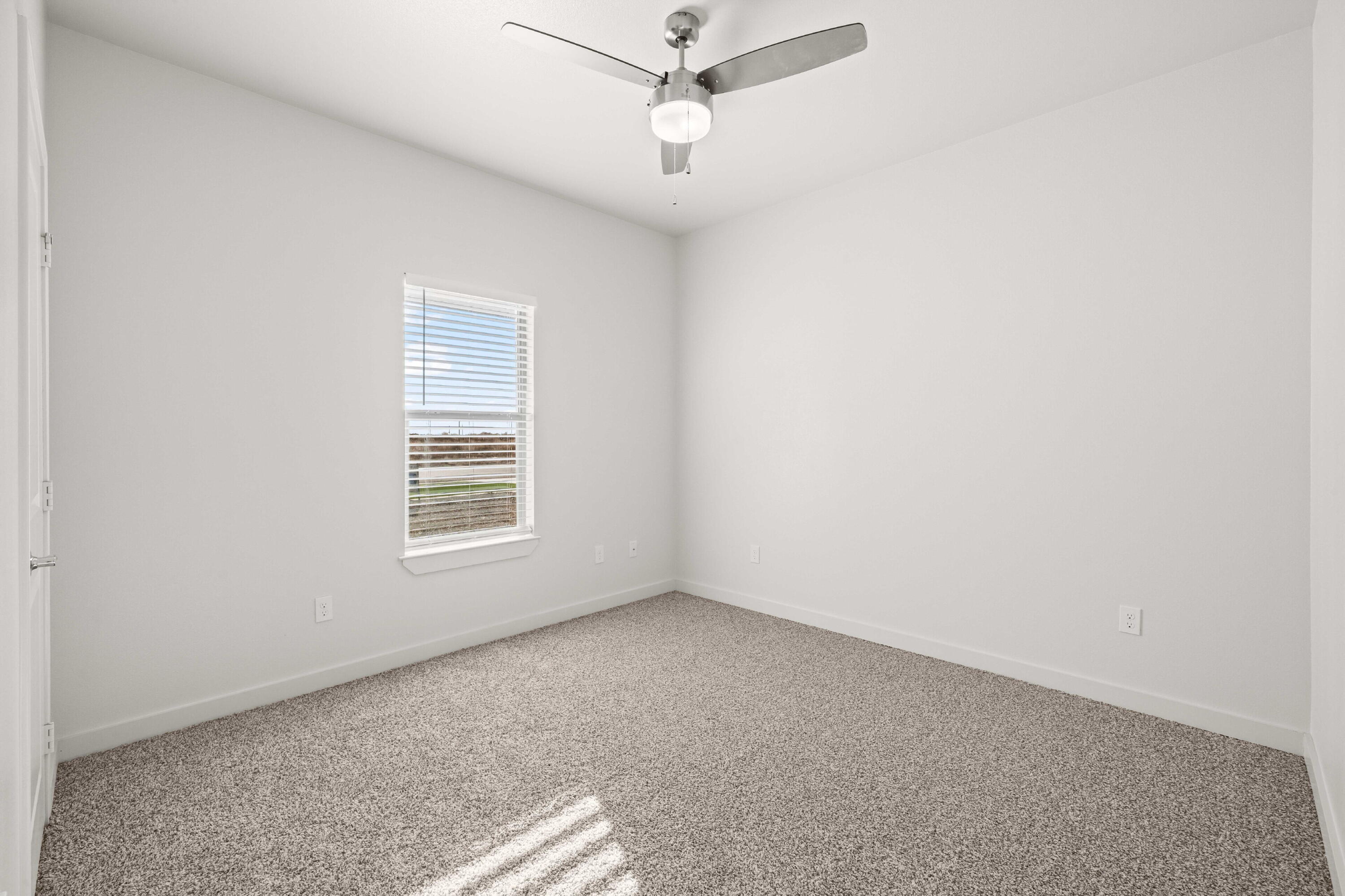 7016 40th Street Lubbock, TX 79407 - Photo 16 of 19 an empty room with a window and a fan