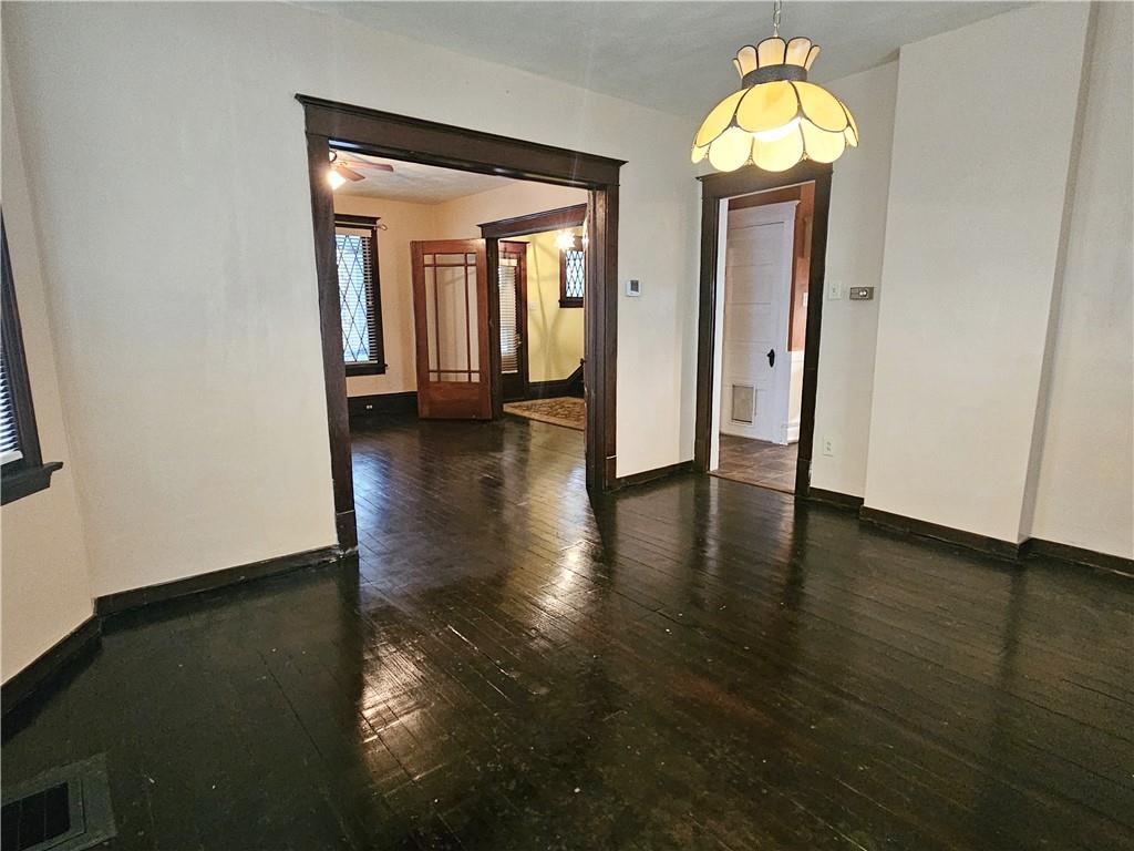 10361 Washington Avenue Irwin, PA 15642 - Photo 14 of 37 an empty room with wooden floor and chandelier