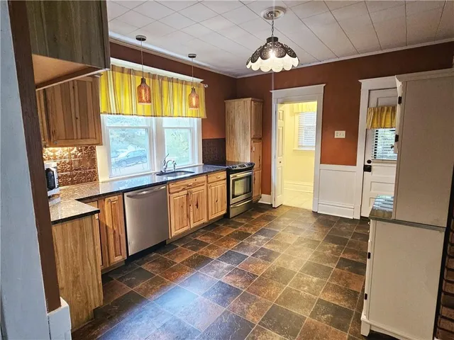 a view of a large kitchen with a sink and windows