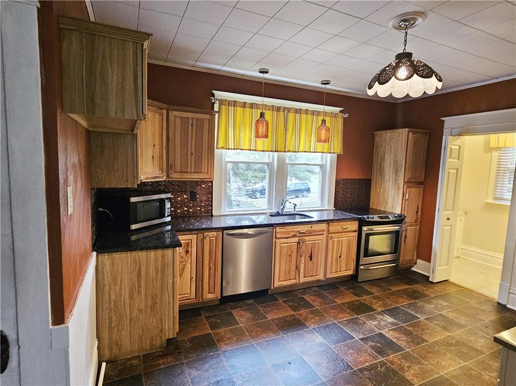 10361 Washington Avenue Irwin, PA 15642 - Photo 18 of 37 a kitchen with stainless steel appliances a stove refrigerator sink and microwave