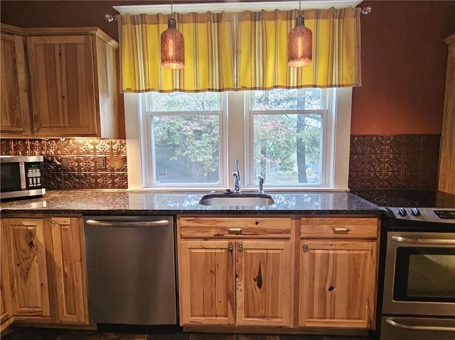 a kitchen with granite countertop wooden cabinets and a window