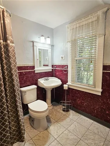 a bathroom with a toilet sink and mirror
