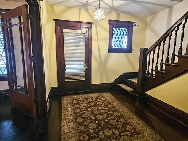 a view of a hallway with wooden floor and staircase