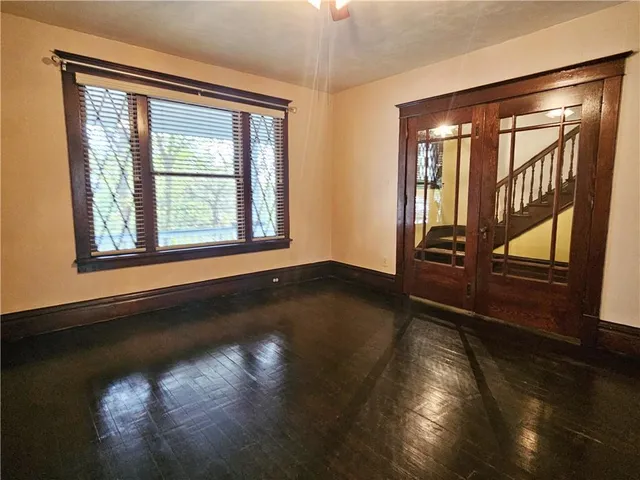 an empty room with wooden floor and windows