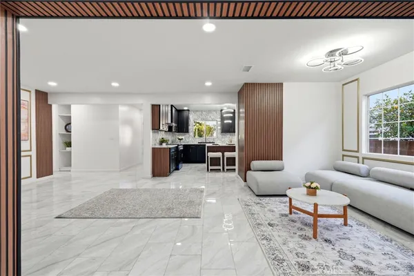 a living room with furniture and a dining table with kitchen view