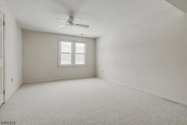 an empty room with a window and a ceiling fan