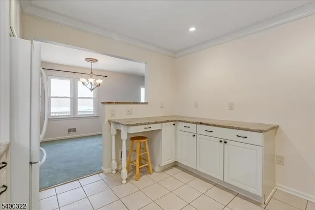a kitchen with white cabinets and window