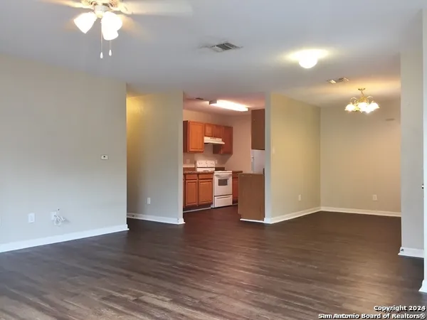 a view of a kitchen with wooden floor and a ceiling fan