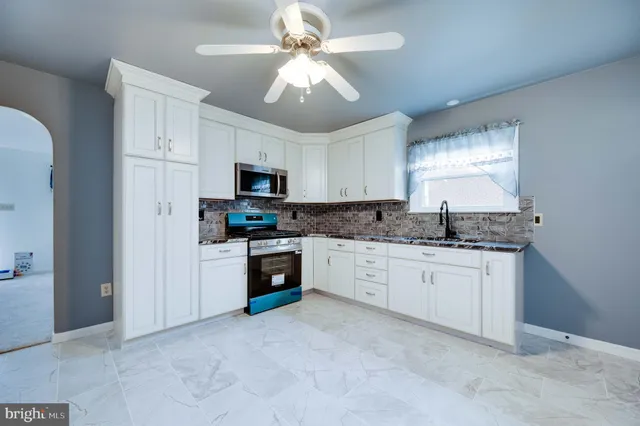 a kitchen with stainless steel appliances granite countertop a stove a sink and a microwave