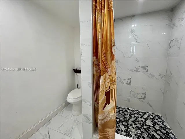 a bathroom with a toilet and a shower
