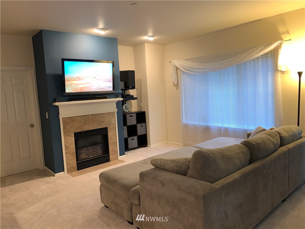 4818 Davis Place South, Unit H Renton, WA 98055 - Photo 3 of 20 a living room with furniture a flat screen tv and a fireplace
