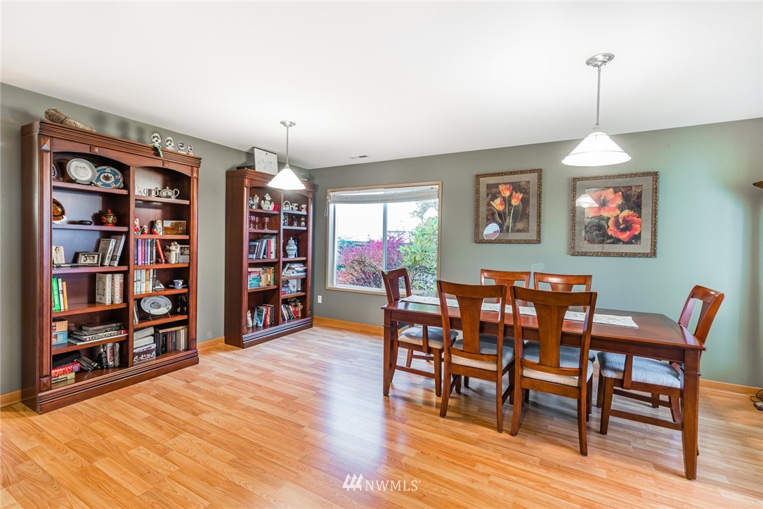 20426 Corbridge Road Southeast Monroe, WA 98272 - Photo 2 of 23 a dining room with furniture a book and wooden floor