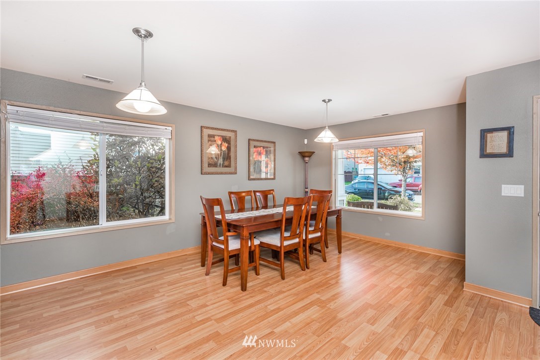 20426 Corbridge Road Southeast Monroe, WA 98272 - Photo 4 of 23 a dining room with wooden floor a chandelier a wooden table and chairs