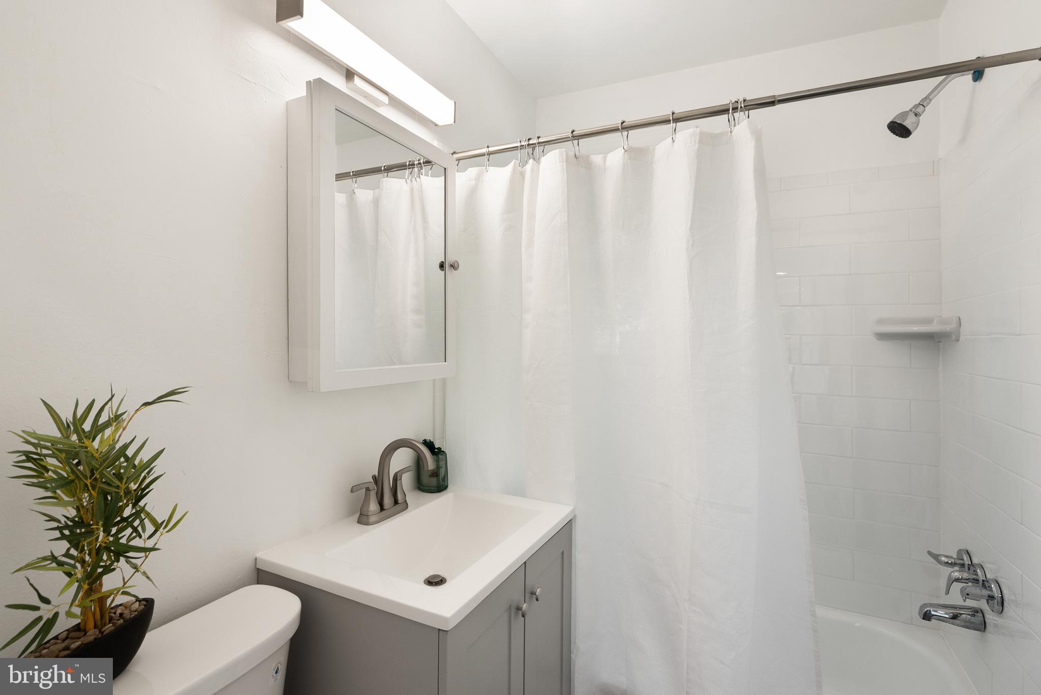 28 East Reed Avenue Alexandria, VA 22305 - Photo 24 of 33 a bathroom with a sink a mirror and a shower curtain