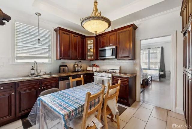 a kitchen with stainless steel appliances granite countertop a stove top oven a sink dishwasher and cabinets with wooden floor