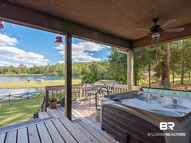 4650 Wiggins Lane Wilmer, AL 36587 - Photo 26 of 66 Deck featuring a water view, a hot tub, a ceiling fan, and a yard