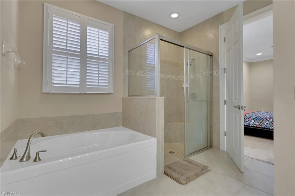 16309 Aberdeen Way Naples, FL 34110 - Photo 17 of 34 a bathroom with a tub shower and window