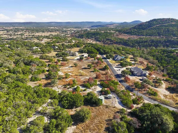 an aerial view of residential houses with outdoor space and trees