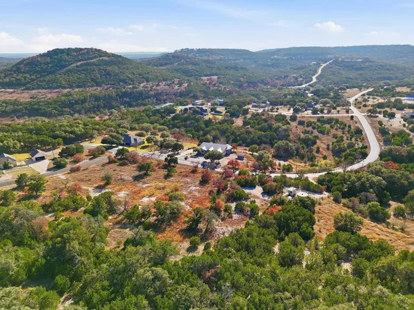 an aerial view of residential houses with outdoor space and trees