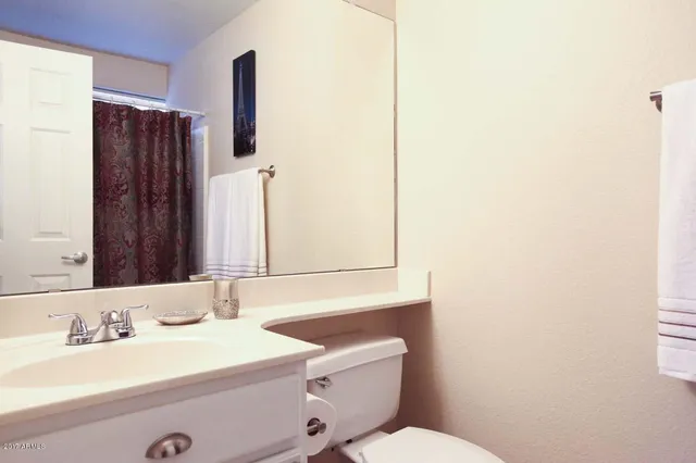 a bathroom with a sink a toilet and mirror