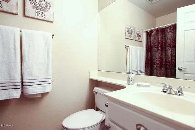 a bathroom with a sink vanity mirror and toilet