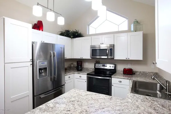 a kitchen with stainless steel appliances granite countertop a refrigerator sink and stove