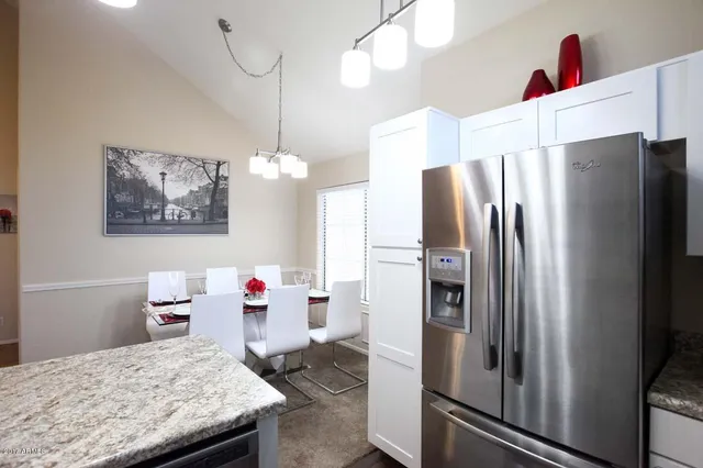 a kitchen view with refrigerator and wooden floor