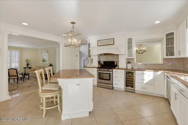 a kitchen with a dining table chairs and white cabinets