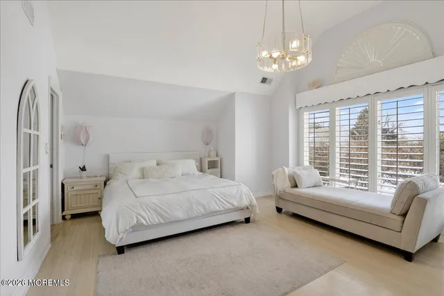 a view of a hallway to a bedroom with furniture