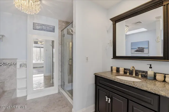 a spacious bedroom with a bed and a chandelier