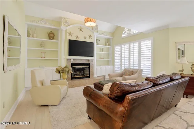 a living room with furniture a fireplace and a flat screen tv