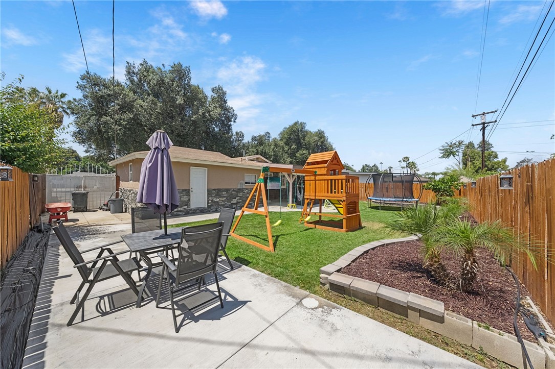 4869 Serrano Place Riverside, CA 92504 - Photo 38 of 40 Spacious backyard featuring a large patio area, lush lawn, and plenty of room for outdoor dining and recreation.