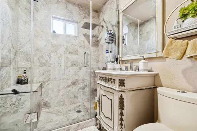 a bathroom with a sink toilet vanity and shower