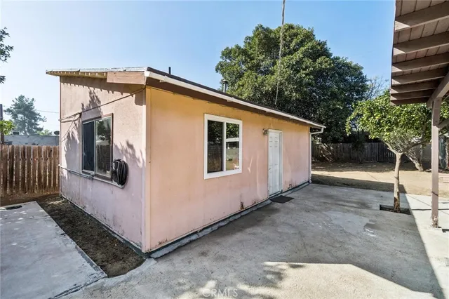 a view of a house with backyard and trees