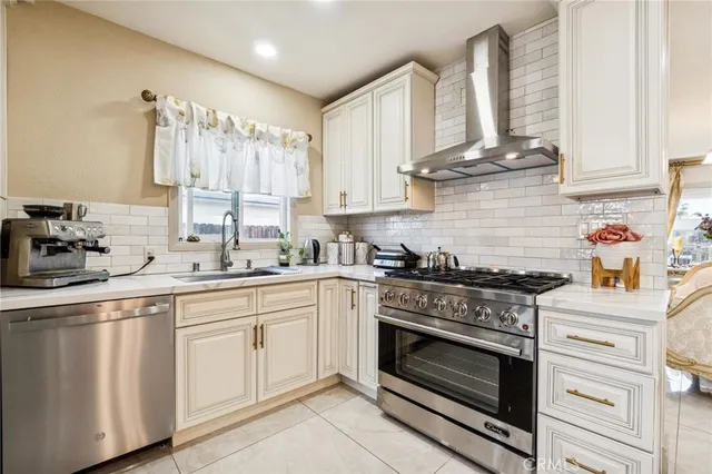 a kitchen with stainless steel appliances a stove a sink and cabinets