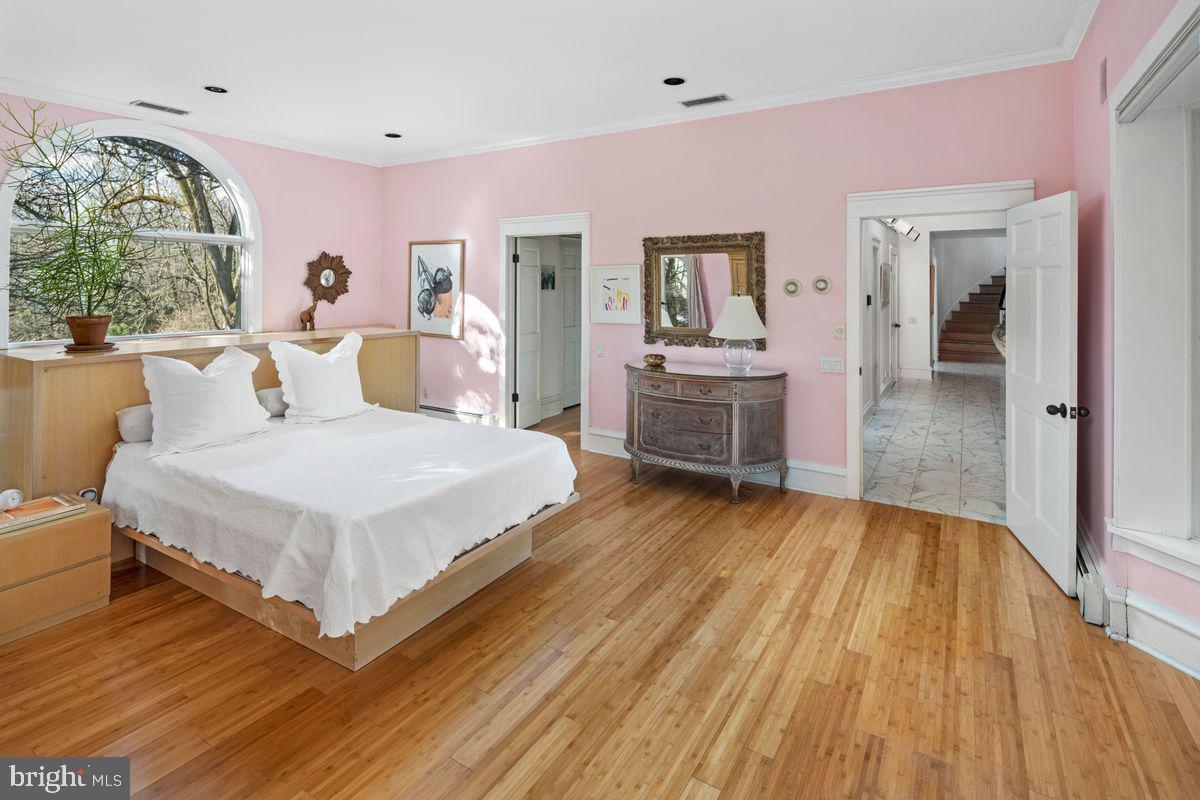 145 East Bells Mill Road Philadelphia, PA 19118 - Photo 24 of 38 a spacious bedroom with a bed and a large window