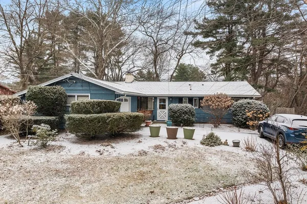 a front view of a house with a yard covered in snow