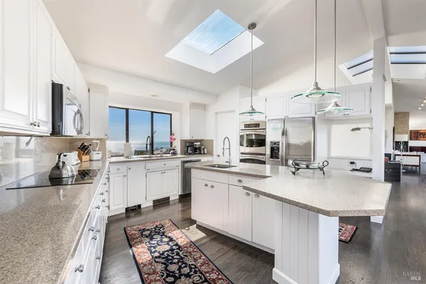 a kitchen with a dining table chairs and chandelier