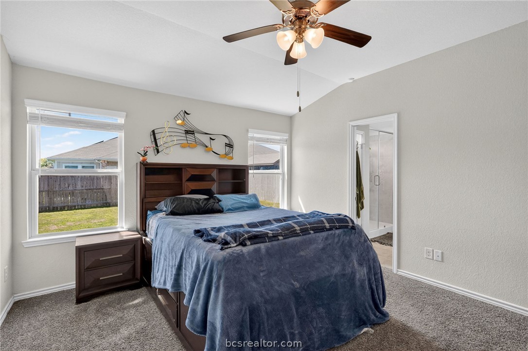 5235 Montague Loop Bryan, TX 77807 - Photo 16 of 25 a bedroom with a bed and a chandelier