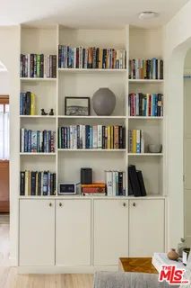 a view of a hallway with wooden floor and cabinet