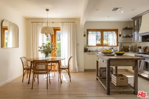 a kitchen with stainless steel appliances granite countertop a table chairs and a refrigerator