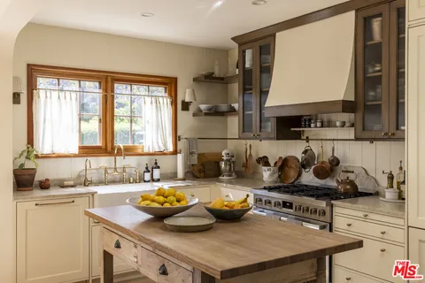 a kitchen with a sink a stove and cabinets