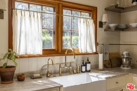 a kitchen with sink and large window