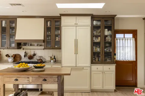 a kitchen with white cabinets and sink
