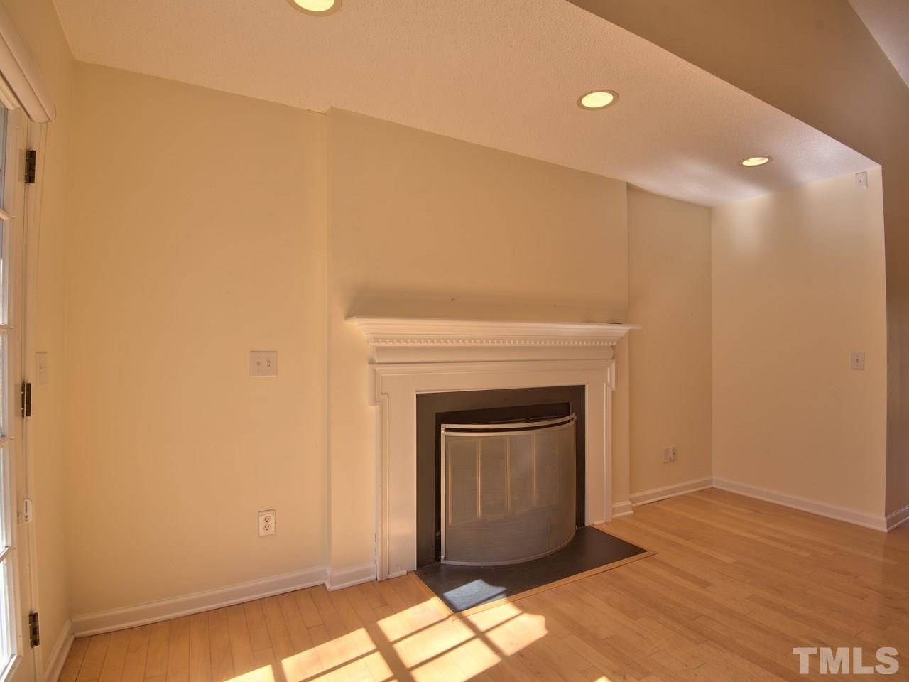 2740 Cottage Circle Raleigh, NC 27613 - Photo 11 of 25 a view of empty room with wooden floor and fireplace