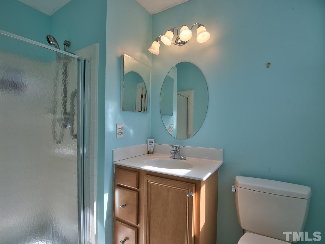 2740 Cottage Circle Raleigh, NC 27613 - Photo 16 of 25 a bathroom with a toilet sink and mirror