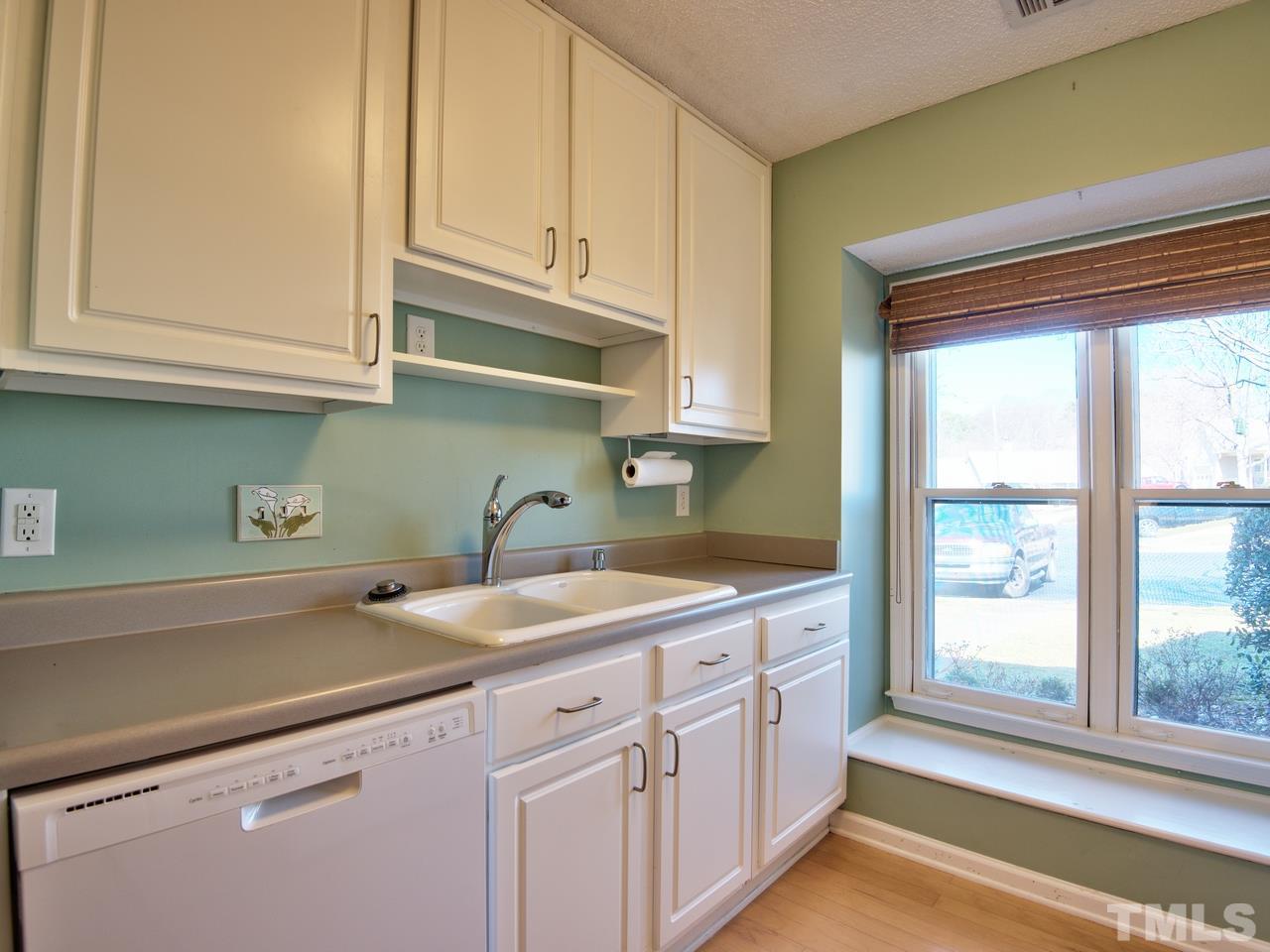 2740 Cottage Circle Raleigh, NC 27613 - Photo 3 of 25 a kitchen with stainless steel appliances granite countertop a sink and a white cabinets with wooden floor