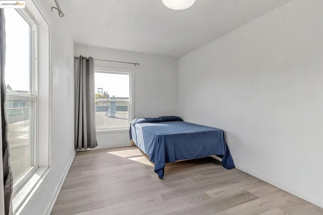 a living room with a bed furniture and next to a window